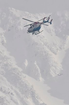 大山上空を飛んで遭難者を捜索する島根県防災ヘリ＝４日午後４時９分、鳥取県大山町大山