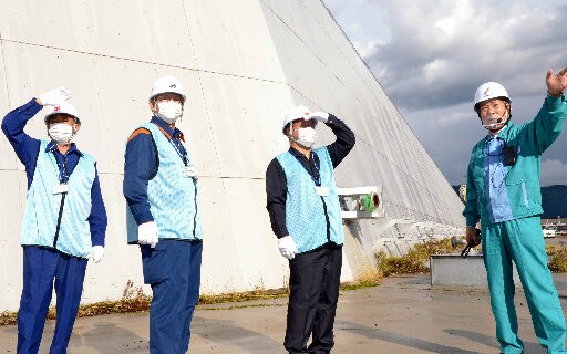 防波壁の前で中国電力幹部から説明を受ける（左から）飯塚俊之市長、田中武夫市長、石飛厚志市長＝松江市鹿島町片句、島根原発
