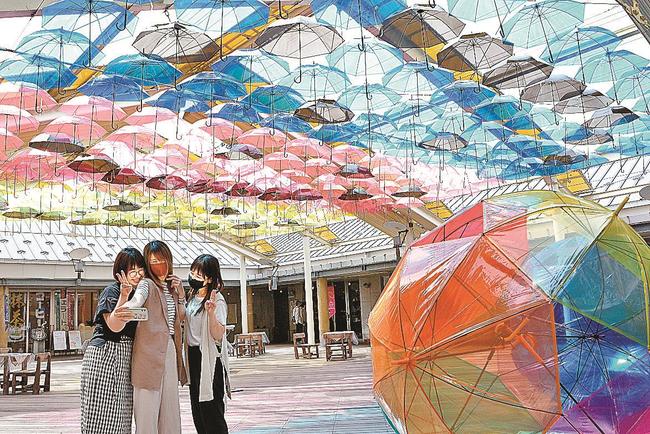 色とりどりの傘アートを楽しむ来場者＝松江市殿町、カラコロ工房