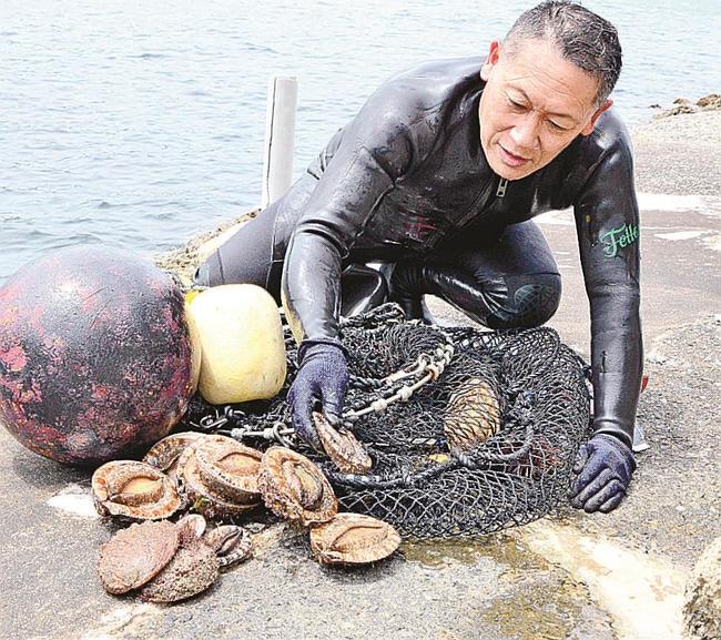 アワビを水揚げする惣津漁業会の森脇康之さん＝松江市美保関町七類