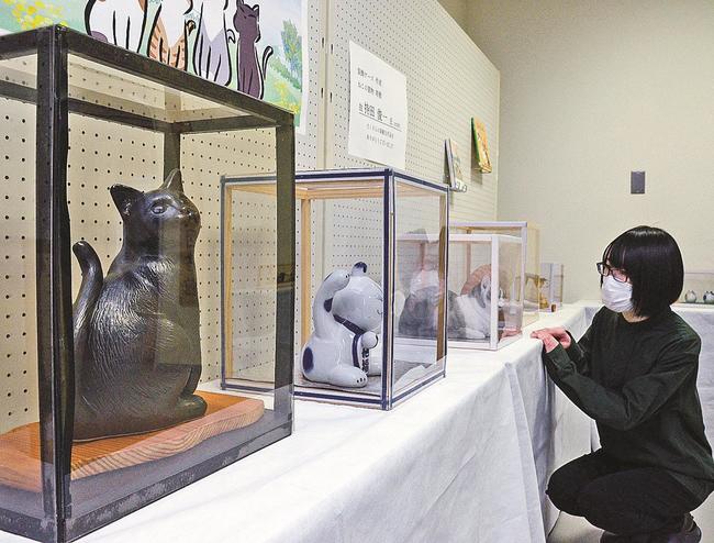 多様な表情のネコの置物が並ぶ会場＝雲南市加茂町加茂中、市立加茂図書館