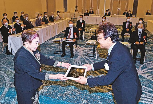松尾倫男社長（右）から表彰状を受け取る佐倉真喜子さん＝松江市千鳥町、ホテル一畑
