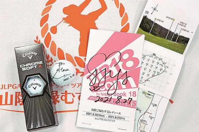 サイン入りの鈴木麻綾選手のヤーデージブック（右）とリハナ選手のホールインワン達成球