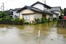 比津川から出た水が迫った民家＝８日午前10時24分、松江市黒田町