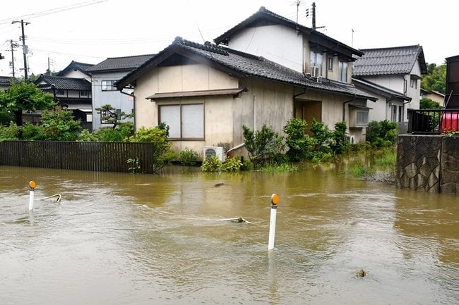 比津川から出た水が迫った民家＝８日午前10時24分、松江市黒田町