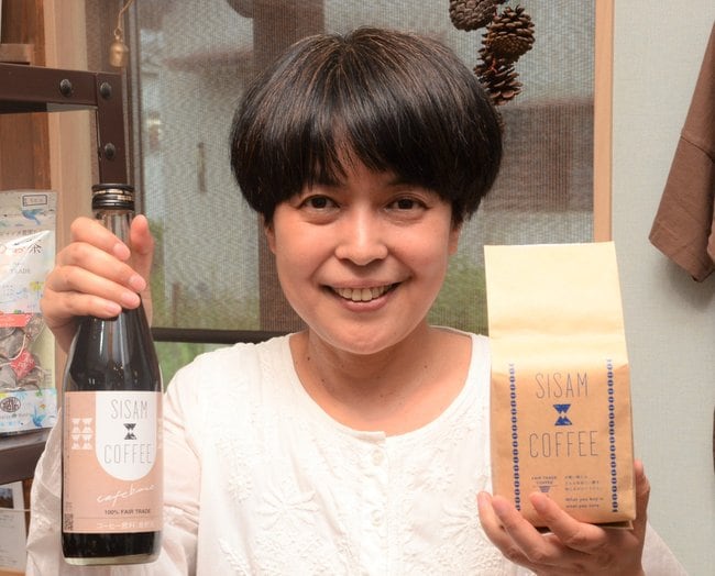 看板商品の「森林農法コーヒー」を手にする森山奈津子さん＝出雲市塩冶有原町、フェアトレードｆｕｋｕ－ｍｉｍｉ