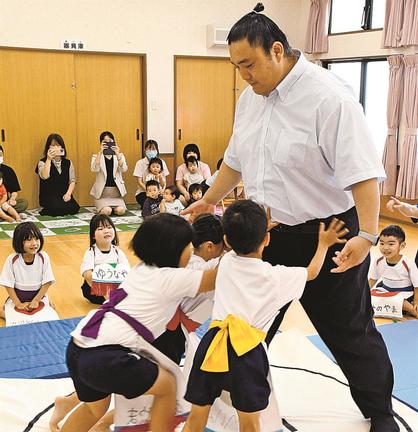 園児と相撲を取って交流する君ケ浜親方＝松江市法吉町、みずうみ保育園