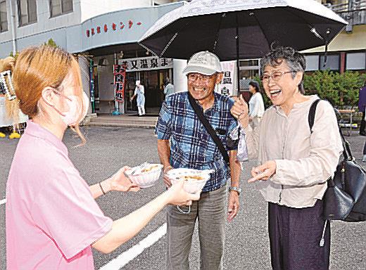 美肌スープを笑顔で受け取る来場者=浜田市金城町追原、美又温泉国民保養センター