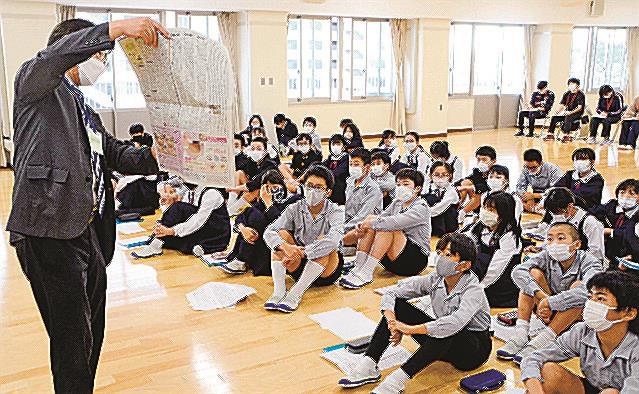 松村健次論説委員長（左）からコラム「明窓」について教わる児童＝松江市大輪町、島根大付属義務教育学校