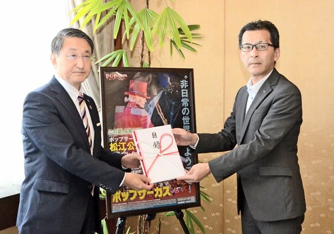 招待目録を手にする平井伸治知事（左）と山田英治取締役事業プロデュース局長＝鳥取市東町１丁目、鳥取県庁
