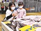 どんちっちアジ（左）を品定めする来場者＝浜田市原井町、山陰浜田港公設市場