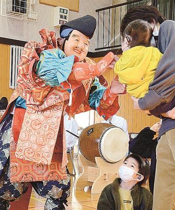 ステージを降り、鑑賞者にあめを配る恵比須役＝浜田市国分町、浜田ろう学校