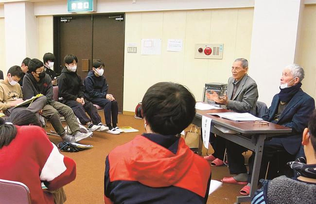 子どもたちに向けて戦争体験を語る地元住民（右）＝２月22日、松江市美保関町下宇部尾、美保関公民館（美保関公民館提供）