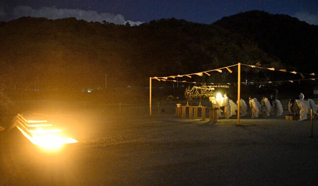 かがり火がたかれた稲佐の浜で、神迎神事を営む神職=14日午後7時10分ごろ、出雲市大社町杵築北