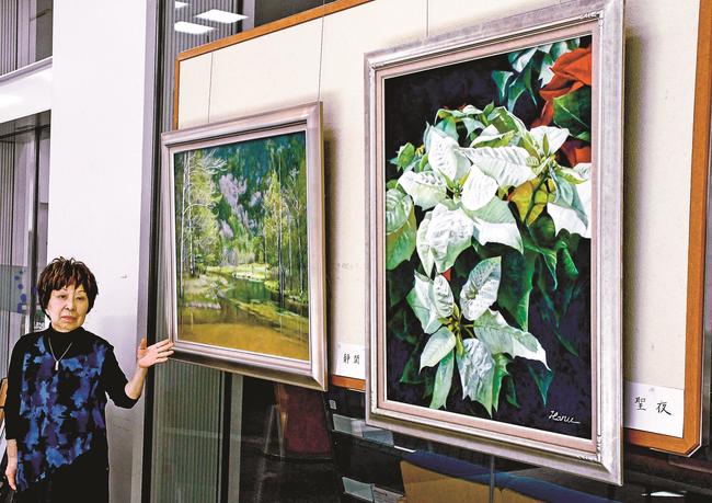 自身の描いた油絵を紹介する髙橋春江さん＝松江市御手船場町、しまね信用金庫