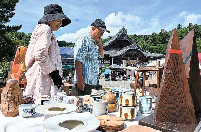 骨董品を品定めする来場者=出雲市大社町杵築東、出雲大社教祖霊社
