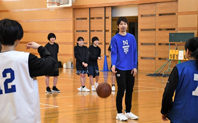 北川弘選手（中央）から指導を受ける東出雲中学校女子バスケットボール部の生徒＝松江市東出雲町揖屋、東出雲中学校
