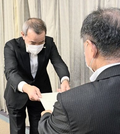 安来市の伊藤徹副市長（手前）に回答文書を手渡す中電島根原子力本部の北野立夫本部長＝松江市殿町、市町村振興センター