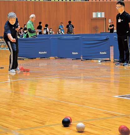 狙いを定めてボールを投げる出場者(左)=浜田市黒川町、島根県立体育館