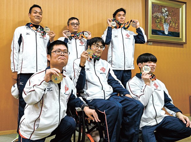 獲得した金メダルを手にする選手や陸上競技の伴走者=松江市殿町、島根県庁