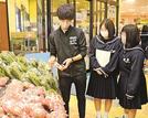 店頭に並ぶ「とまとまるドレッシング」を確認する板本大輝さん（左）ら浜田商業高校の生徒＝浜田市黒川町、キヌヤプリル店