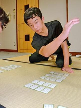 一瞬の早業で札を取る間野颯太さん＝益田市七尾町の「いわみの記念館」