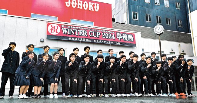 全国大会準優勝をたたえる横断幕の前でポーズをとるバスケットボール部員たち＝鳥取市西品治、鳥取城北高校