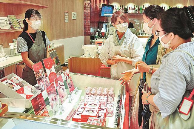 「ご縁をむすび」を買い求める来館者（右）＝東京都千代田区、日比谷しまね館