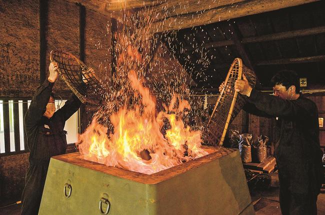 炉に木炭を入れる社員＝雲南市吉田町吉田
