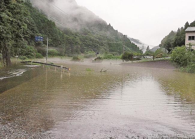 江の川にせき止められた水があふれた三谷川。左は冠水した県道１８７号＝１３日午後３時５７分、島根県川本町川本