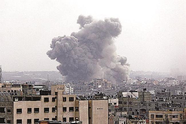 ２９日、ガザ市でイスラエル軍による空爆後、立ち上る煙（ＡＰ＝共同）