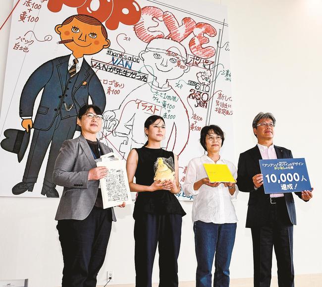 来場１万人目の記念品を受け取った徳田さん親子（中央）＝松江市袖師町、島根県立美術館
