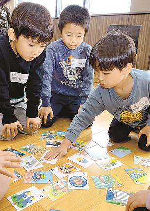 建設業の仕事や工事車両を題材にしたかるたに挑戦する児童＝出雲市姫原町、中筋組