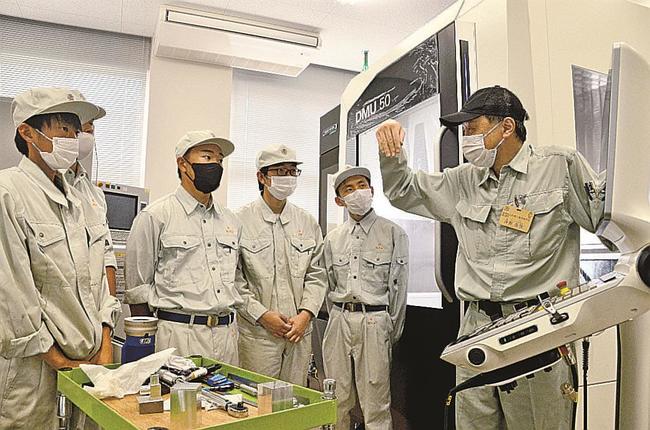 課題研究で「５軸マシニングセンタ」の操作を学ぶ機械科の３年生＝出雲市上塩冶町、出雲工業高校