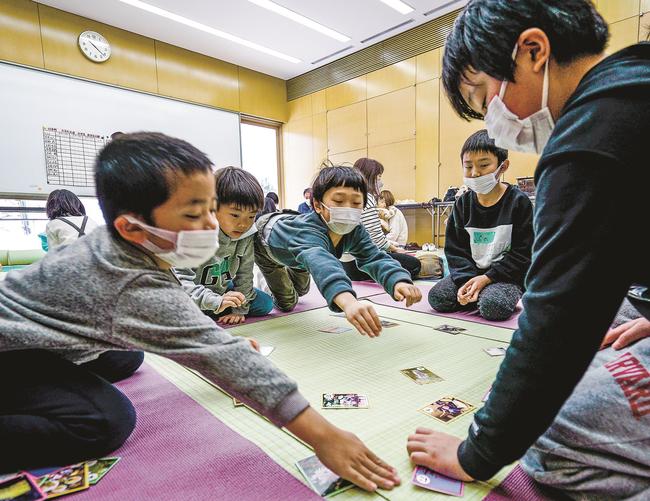 勢いよく絵札に手を伸ばす児童＝島根県川本町川本、悠邑ふるさと会館