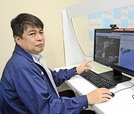 パソコン画面に映し出した台風の進路予想を指さす海老政徳さん。