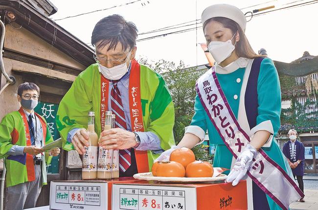 「輝太郎」など供える、わかとりメイツの尾形愛美さん(右)ら=境港市大正町、妖怪神社