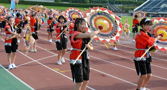 傘踊りを披露する踊り子たち＝鳥取市布勢、ヤマタスポーツパーク陸上競技場