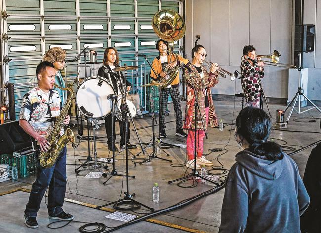 ノリのいい演奏を披露する「ＢＬＡＣＫ　ＢＯＴＴＯＭ　ＢＲＡＳＳ　ＢＡＮＤ」のメンバー＝益田市内田町、萩・石見空港貨物ビル