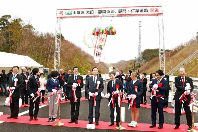 テープカットで山陰道大田・静間道路と静間・仁摩道路の開通を祝う関係者＝大田市静間町、大田静間インターチェンジ付近