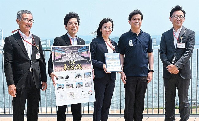 松江城天守国宝１０周年を記念したオリジナルフレーム切手を持つ日本郵便社員らと上定昭仁市長（左から４人目）＝松江市末次町、市役所