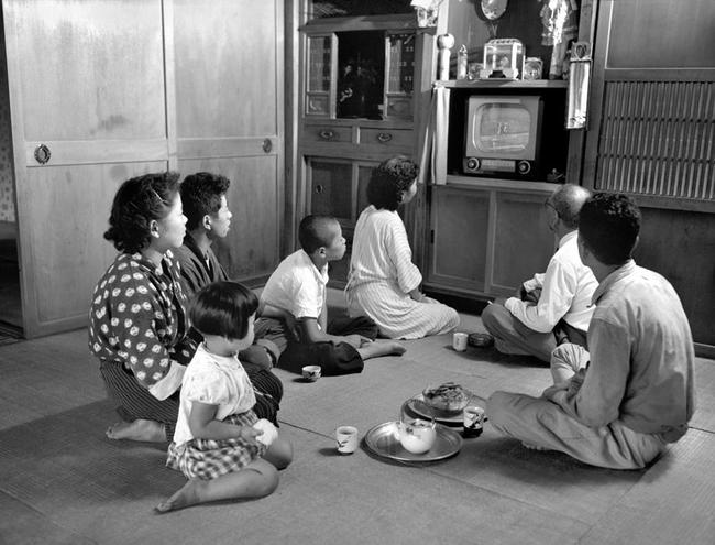 農家の家族そろって視線を向けるのは居間に据えた白黒テレビ。洗濯機、冷蔵庫とともに家電品の「三種の神器」が神武景気に乗って普及し始めた＝１９５６（昭和３１）年９月