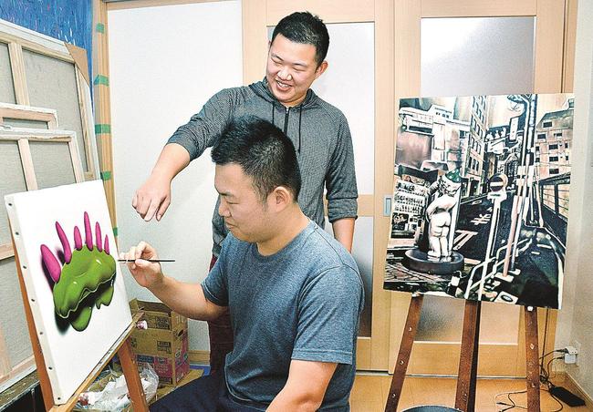 作品制作する兄の木原幸志郎さん（左）にアドバイスする木原健志郎さん＝尾道市