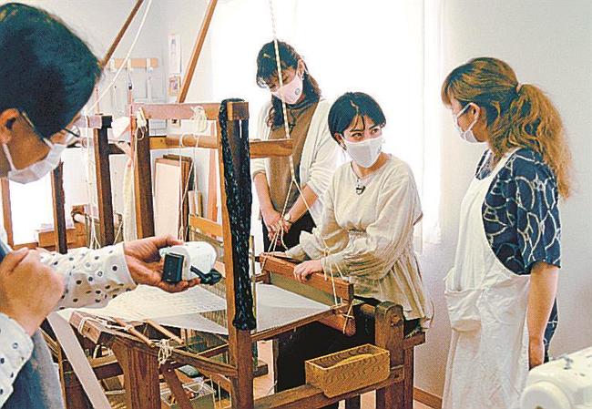 機織りに挑戦する薄田ジュリアさん（右から二人目）と加納永美子さん（同３人目）＝境港市中野町、弓浜絣工房Ｂ