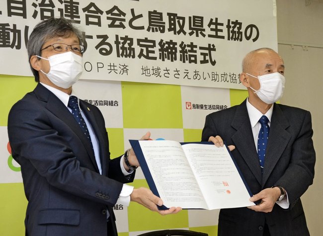 協定書を掲げる井上約理事長(左)と福島雄三会長=米子市永江、支え愛の店ながえ