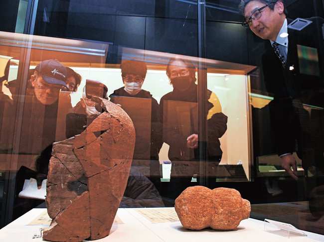 下黒田遺跡で出土した備前焼のつぼを見る来館者ら=松江市大庭町、八雲立つ風土記の丘