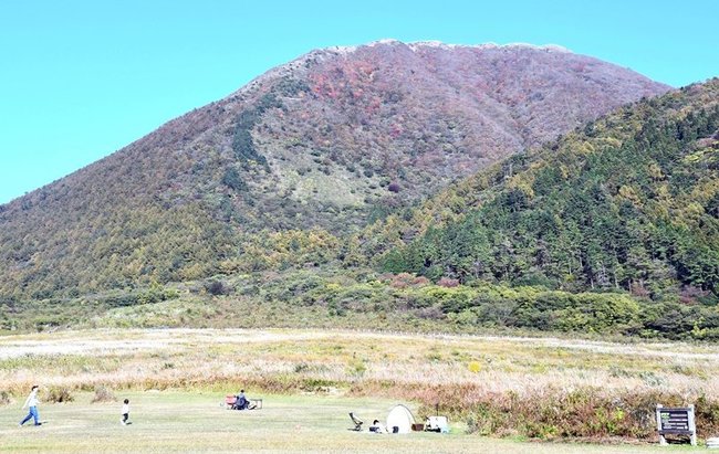 紅葉が見ごろを迎えた男三瓶山（中央）と子三瓶山（手前右）。西の原では大勢の家族連れが訪れている＝大田市三瓶町