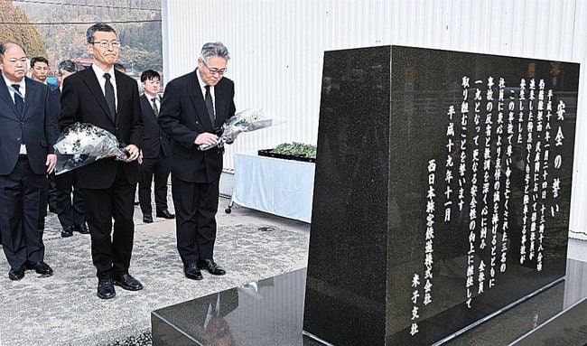 安全碑に花束を手向ける佐伯祥一本部長（右）と金岡裕之山陰支社長＝鳥取県日野町根雨