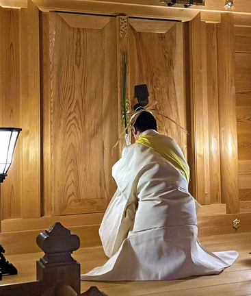 梅の枝で扉をたたき、神々に出発の時を知らせる錦田剛志宮司=出雲市斐川町併川、万九千神社