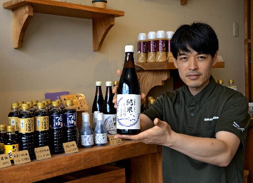 アレルギーの心配なく食卓で使える「お米から造った純米しょうゆ」を紹介する山本周作専務＝安来市伯太町東母里、大正屋醤油店